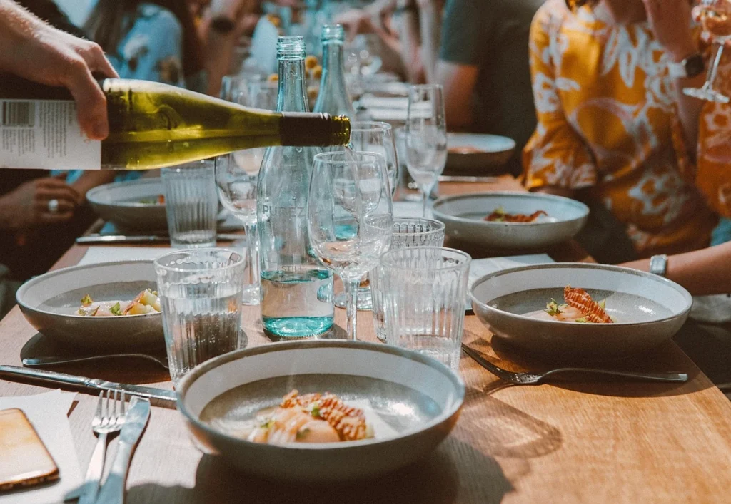 Table dressée avec assiettes, verres de vin et plats gourmands entre amies