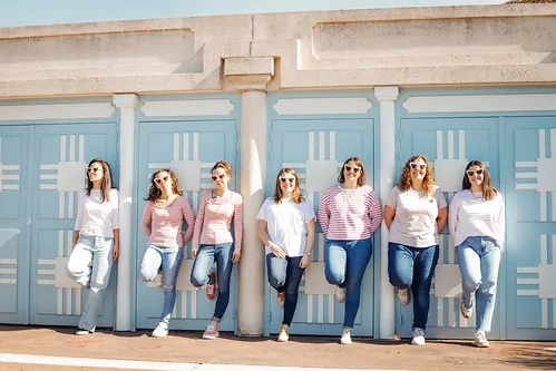 groupe de femmes alignees devant des cabines bleues
