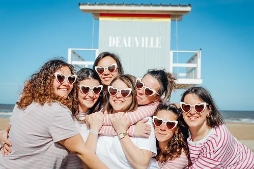 groupe de femmes avec lunettes coeur souriantes sur la plage pour chasse au tresor evjf a deauville