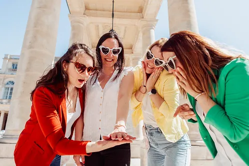 groupe de femmes admirant une bague lors d une chasse au tresor evjf paris devant un monument