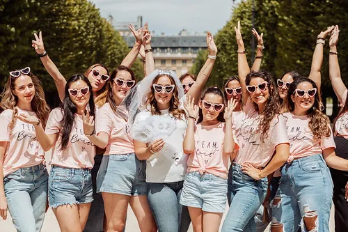 groupe de femmes en t shirts roses celebrant ensemble lors d une chasse au tresor evjf paris dans un parc