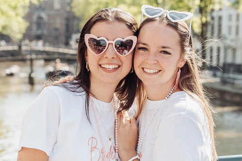 deux amies souriantes posant ensemble pres des canaux