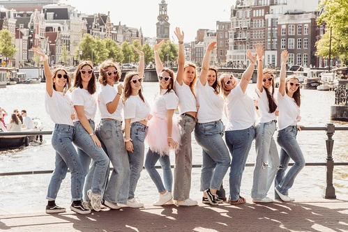 groupe de femmes souriantes posant pour un evjf lors d’un city game à amsterdam près des canaux