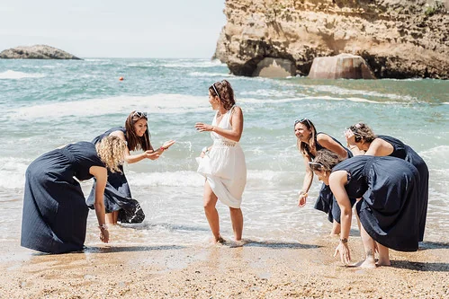 La mariee et ses amies jouent sur le sable face a l ocean a Biarritz pendant un city game evjf biarritz ambiance joyeuse