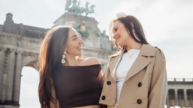 Deux amies sourient devant un monument emblématique