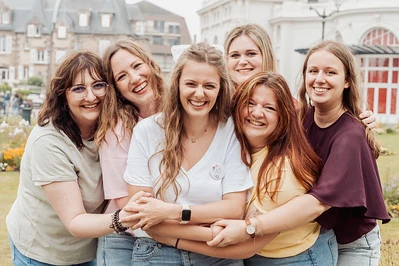 Groupe de copines souriantes enlacées lors d’un city game EVJF à Cabourg dans une ambiance joyeuse et conviviale.