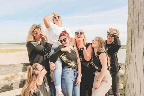 groupe de copines riant ensemble pendant un city game evjf le touquet sur une jetee en bord de mer