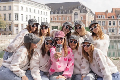 groupe de filles en lunettes cœur faisant un selfie pendant un city game evjf lille en extérieur