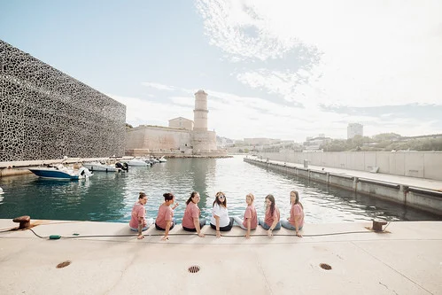 groupe de copines assises face au vieux port de marseille lors d un city game evjf marseille en bord de mer