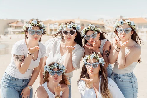 groupe de filles qui envoient des bisous a la camera pendant un city game evjf montpellier sur la plage