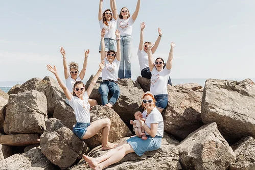 groupe de filles assises sur les rochers en bord de mer avec ambiance detendue entre copines
