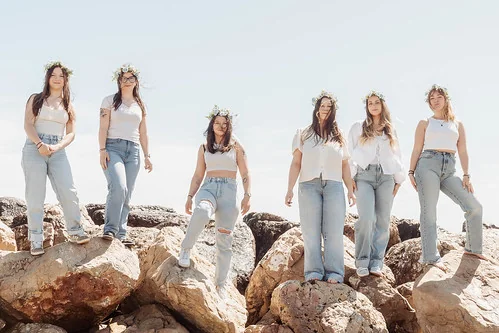 groupe de filles sur les rochers avec couronnes de fleurs pendant un city game evjf montpellier en bord de mer