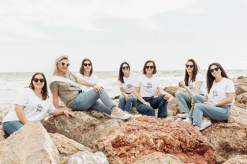 groupe de femmes pour un clip video evjf montpellier assises sur des rochers face a la mer