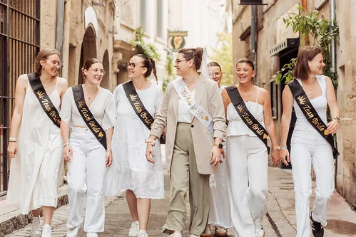 groupe de femmes marchant dans une rue pour un clip video evjf montpellier avec des echarpes de team bride