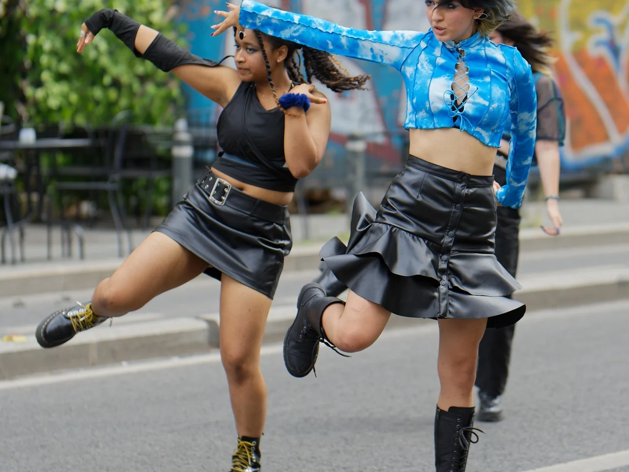 Deux danseuses effectuant une chorégraphie urbaine en plein air sur une rue pavée