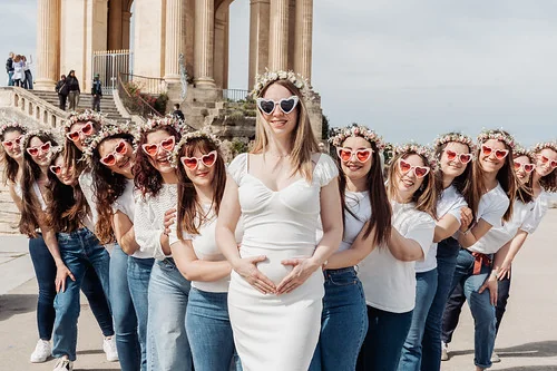 10 bonnes raisons de faire un evjf à montpellier : groupe de copines devant un monument posant avec lunettes cœur et couronnes de fleurs