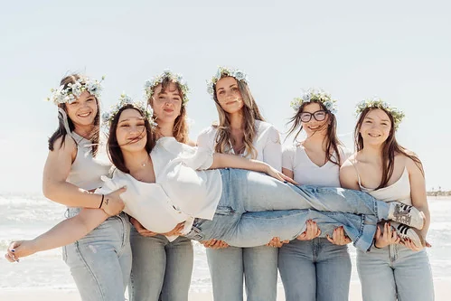 10 bonnes raisons de faire un evjf à montpellier : copines portant la future mariée sur la plage en riant