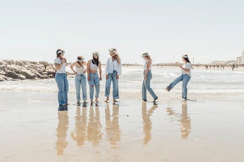 10 bonnes raisons de faire un evjf à montpellier : groupe de copines sur la plage avec reflet dans l’eau en pleine ambiance joyeuse