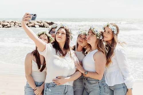 10 bonnes raisons de faire un evjf à montpellier : selfie entre copines sur la plage avec couronnes de fleurs et sourire