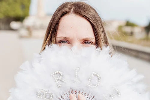 portrait d une future mariee tenant un eventail blanc bride