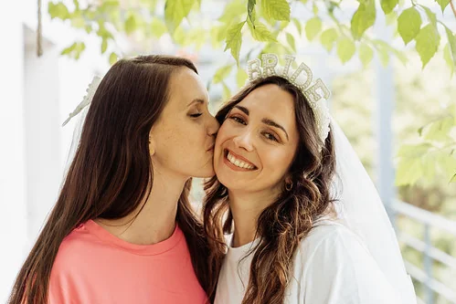 future mariee souriante portant un diademe bride embrassee par une amie