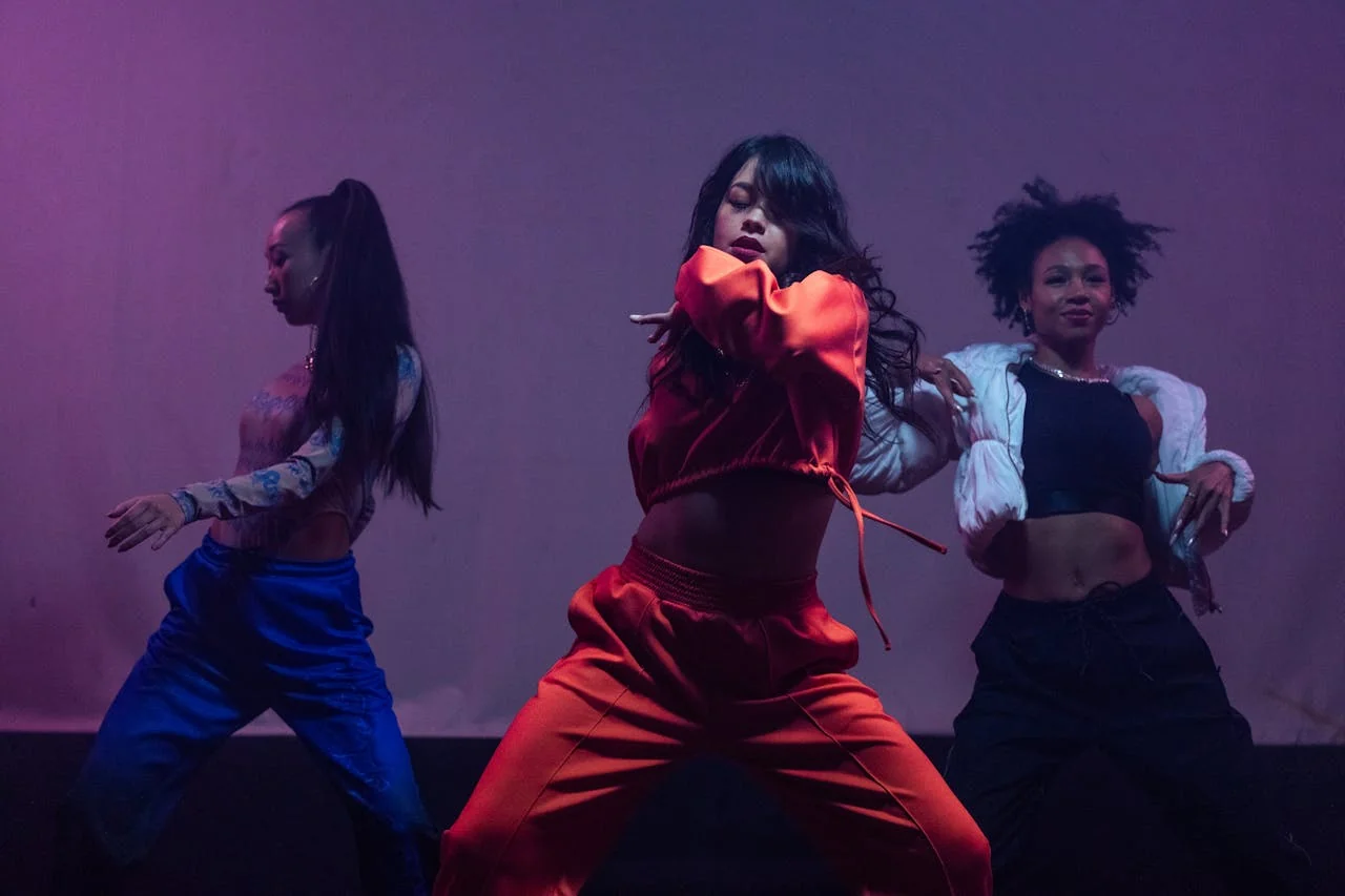 Groupe de danseuses en tenue colorée effectuant une chorégraphie urbaine sur scène