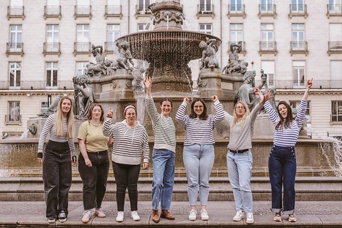 groupe de femmes celebrant un evjf devant une fontaine à nantes pendant un week end entre amies