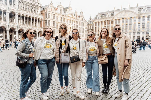 groupe de femmes souriantes posant sur la grand place pendant un jeu de piste evjf paranormal à bruxelles