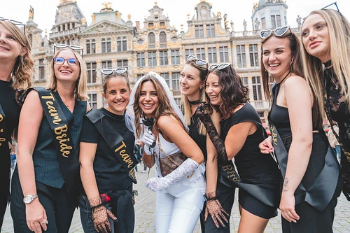 groupe de femmes souriantes team bride participant à un jeu de piste evjf paranormal à bruxelles sur la grand place