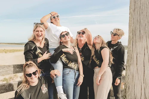 groupe d’amies riant sur la plage pendant un jeu de piste evjf paranormal au touquet