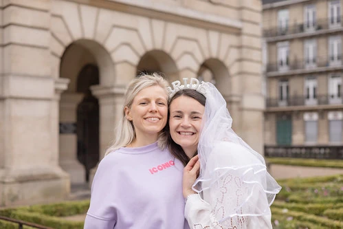 deux amies souriantes lors d’un jeu de piste evjf paranormal à lille devant un bâtiment historique
