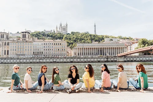 groupe de femmes assises au bord de la saone a lyon avec vue sur fourviere pendant le jeu de piste evjf paranormal lyon
