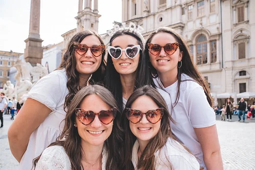 groupe de femmes souriantes celebrant un evjf a rome sur une place historique