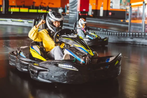 femme en combinaison et casque pilote un karting en salle lors d un evjf a nantes