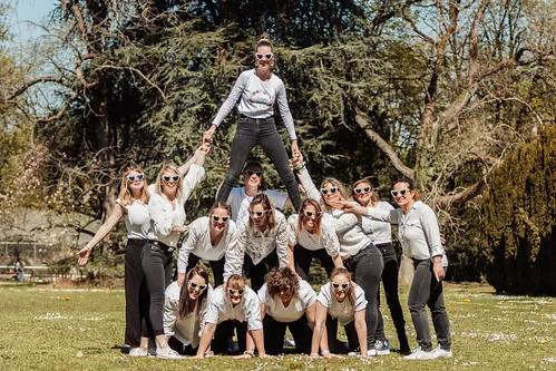 Groupe de filles formant une pyramide humaine en extérieur avec ambiance