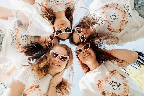 groupe de femmes en cercle avec t shirts assortis et lunettes en forme de coeur