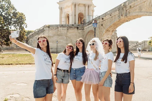 groupe de femmes en t shirts assortis prenant un selfie pendant un evjf à montpellier près du château d eau du peyrou