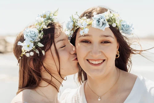 deux femmes portant des couronnes de fleurs bleues souriantes