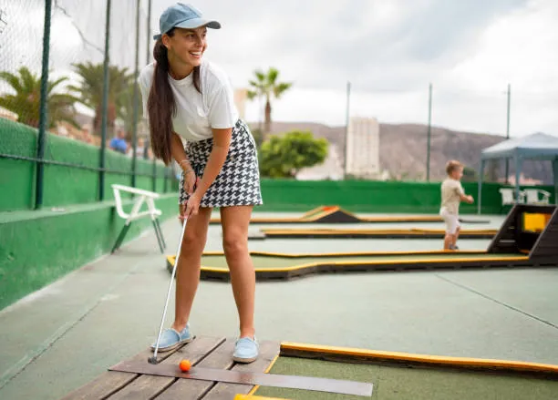 femme souriante joue au mini golf en plein air