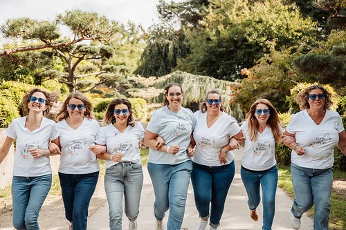groupe de femmes souriantes participant a un evjf a nantes dans un parc en tenues assorties
