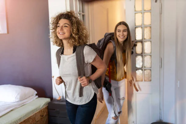 deux femmes arrivent dans leur logement a nantes avec sacs a dos pour un week end evjf