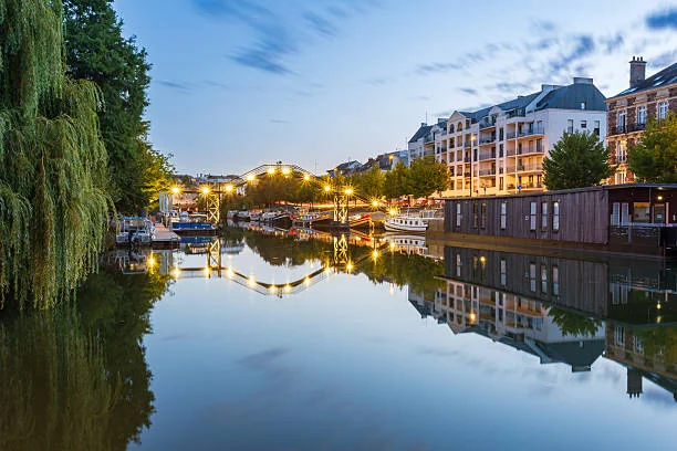 quais de nantes au coucher du soleil avec péniches et logements en bord de loire