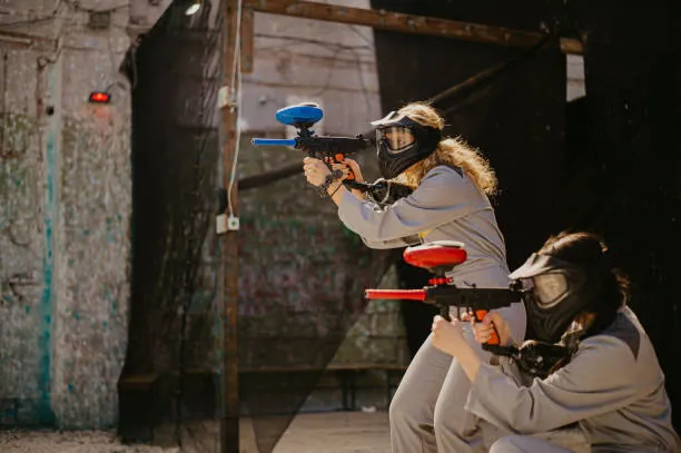 deux femmes en tenue de protection jouent au paintball lors d un evjf a nantes