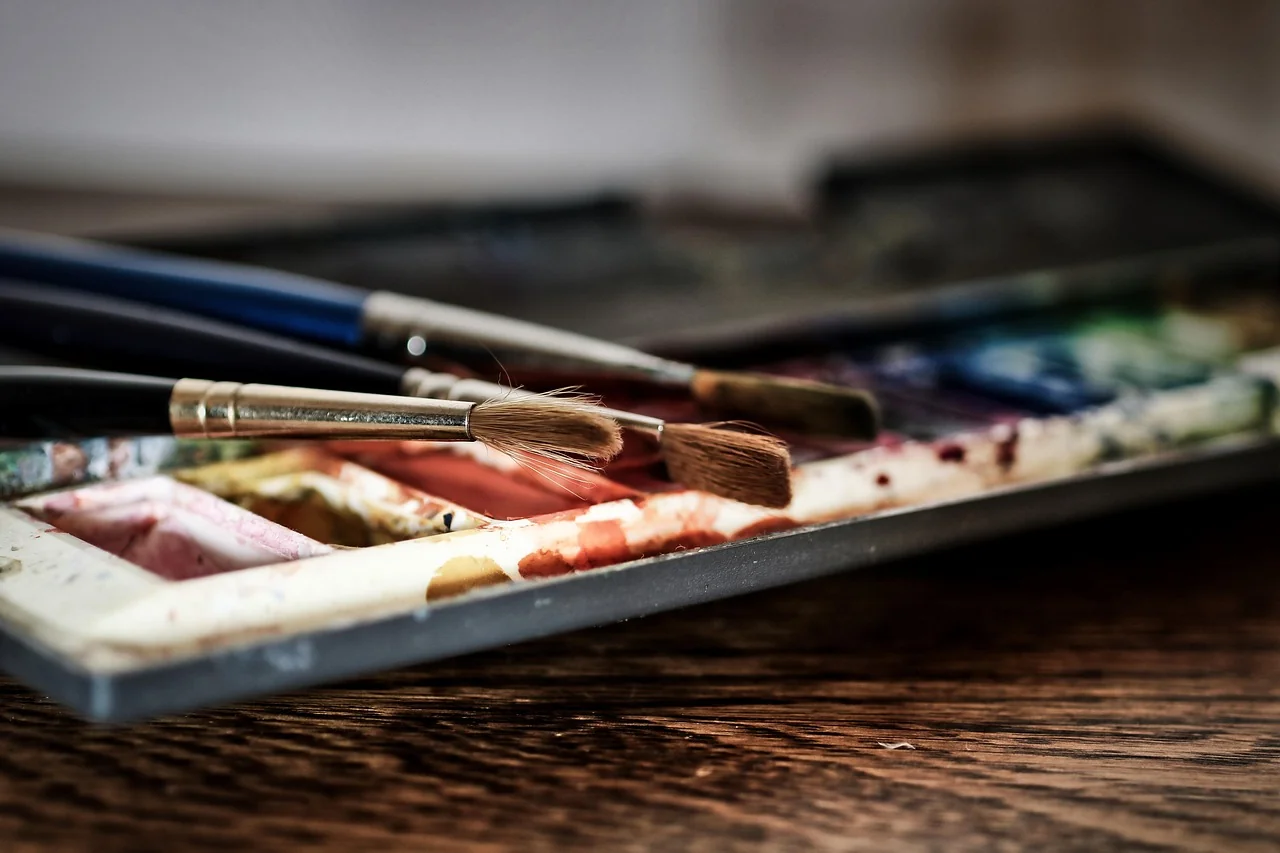 Palette de peinture colorée avec pinceaux sur une table en bois