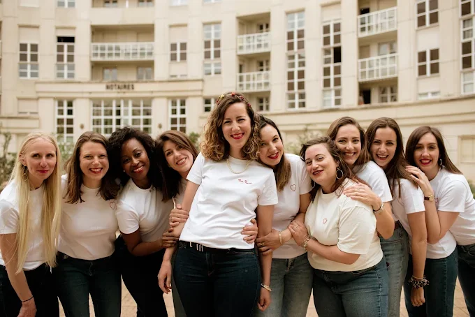 groupe de femmes celebrant un evjf a montpellier posant dans le quartier antigone devant un immeuble moderne
