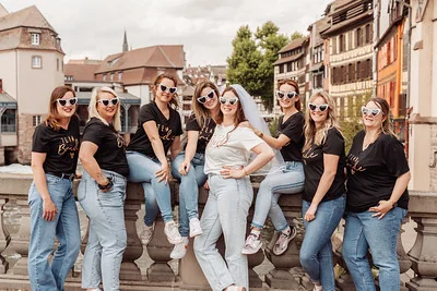 groupe de femmes portant des t-shirts team bride posant avec la future mariée à strasbourg pendant un jeu de piste evjf paranormal
