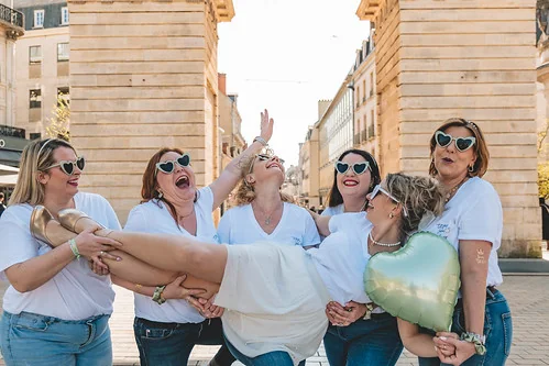 Groupe d’amies portant la future mariée en riant sous l’Arc de Triomphe de Dijon, illustrant l’article 10 bonnes raisons de faire un EVJF à Dijon