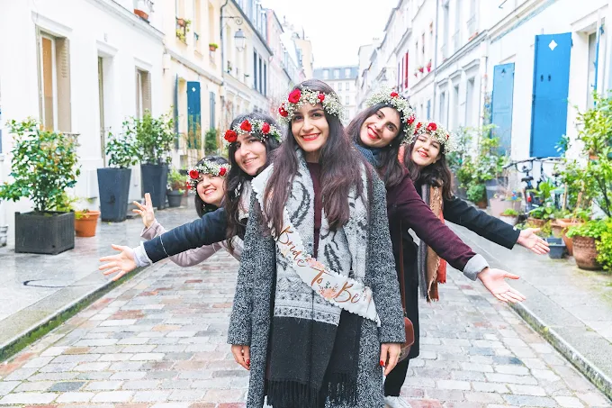 groupe de femmes portant des couronnes de fleurs dans une rue parisienne pendant un evjf a paris