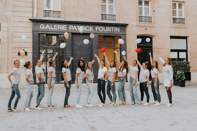 groupe de femmes lançant des ballons colorés dans une rue parisienne pendant un evjf a paris