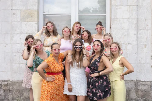 Groupe de femmes portant des lunettes roses en forme de cœur lors d’un EVJF à Lille, illustrant les 10 endroits où sortir à Lille pendant un EVJF.